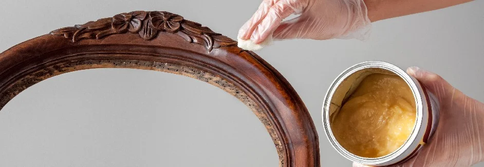 Person trägt Wachs auf antiken Stuhl auf